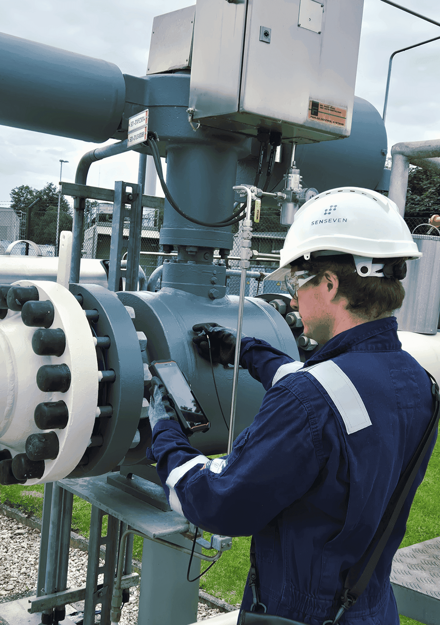 Michael Hettegger inspecting a control valve with the Valve Sense sensor and smartphone